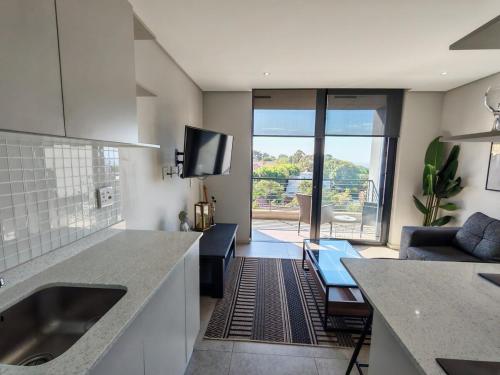 una cucina con lavello e un soggiorno di 707 2six2 Florida Rd- corporate 1 bedroom a Durban