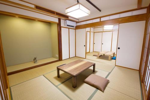 a room with a table and a bench in it at 癒しの空間 One Earth in Akamine