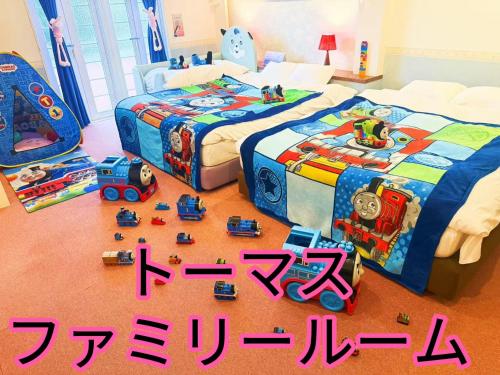 two beds with toys on the floor in a bedroom at Ikaho no mori Kids Paradise in Ikaho
