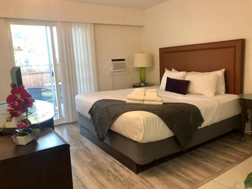 a bedroom with a large bed and a balcony at The Spot in Nanaimo