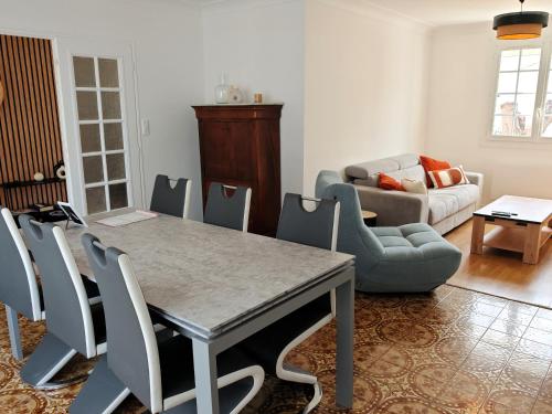 un salon avec une table, des chaises et un canapé dans l'établissement Les Chouans, à Les Sables-dʼOlonne