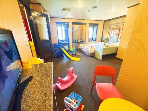 a bedroom with a play room with a bed and a slide at Ikaho no mori Kids Paradise in Ikaho