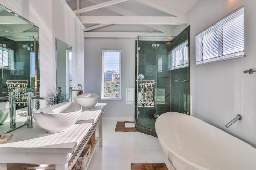 a large bathroom with two sinks and a tub at Nordic Family Beach House in Bettyʼs Bay