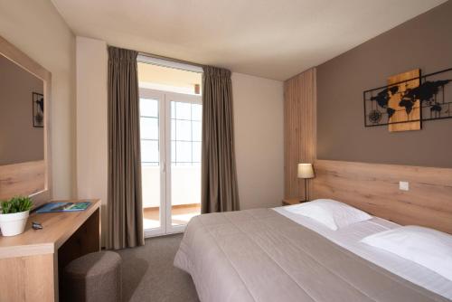 a hotel room with a bed and a window at Marina Alimos Hotel Apartments in Athens