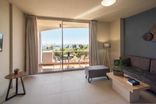 a living room with a couch and a large window at Marina Alimos Hotel Apartments in Athens