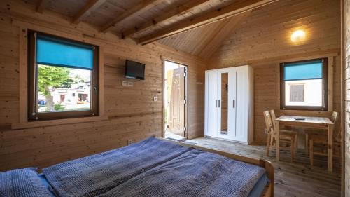a bedroom with a bed and a table and windows at O.W.Cynamon in Dziwnów