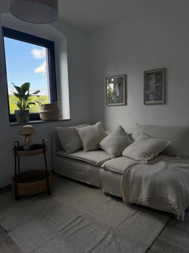 ein Wohnzimmer mit einer Couch und einem Fenster in der Unterkunft Mams-Cottage-Olivia in Harnischdorf