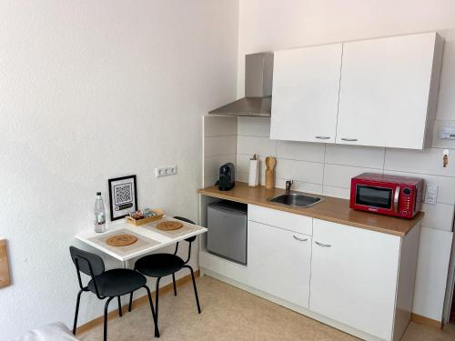 a small kitchen with a small table and a microwave at Idylle Apartments - Park & Therme in Bad Ems