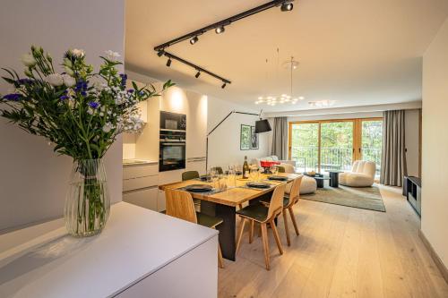 une cuisine et une salle à manger avec une table et un vase de fleurs dans l'établissement Paradisa- Mer de Glace, à Chamonix-Mont-Blanc