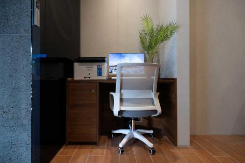 an office with a white chair and a desk with a computer at Moor Hotel Mokpo By Aank in Mokpo