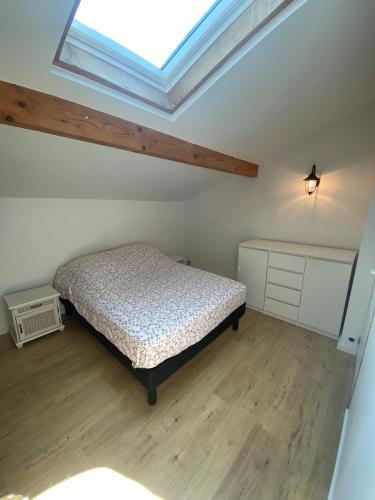 une chambre avec un lit et une lucarne dans l'établissement Maison mitoyenne au coeur du Pays Basque proche mer, montagne, à Mendionde