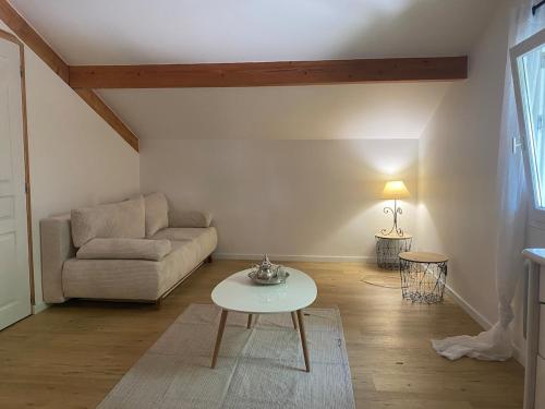 un salon avec un canapé et une table dans l'établissement Maison mitoyenne au coeur du Pays Basque proche mer, montagne, à Mendionde