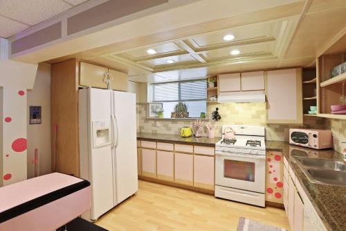 a kitchen with a white refrigerator and a sink at Barbiecore Dream Pad in Sacramento in Sacramento