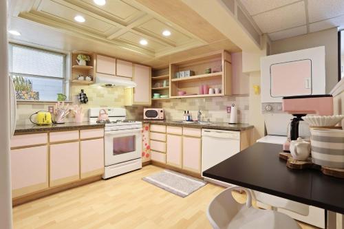 a kitchen with white appliances and a black counter top at Barbiecore Dream Pad in Sacramento in Sacramento