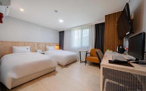una camera d'albergo con due letti e una scrivania di Hotel Ryan a Sacheon