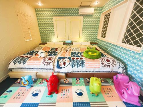 a bedroom with a bed with stuffed animals on it at Ikaho no mori Kids Paradise in Ikaho