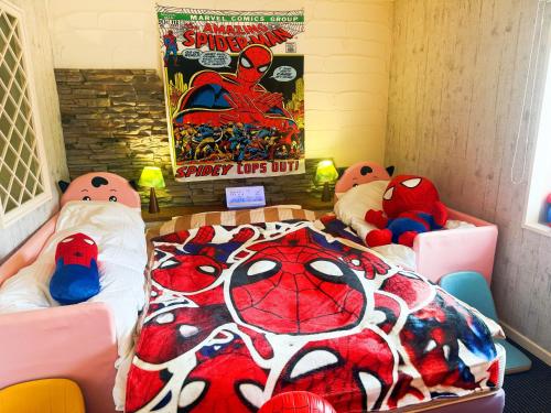 a room with two beds and a spider man bedspread at Ikaho no mori Kids Paradise in Ikaho