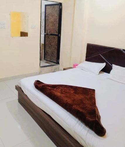 a large white bed with a brown blanket on it at Hotel Priyan-Shi Palace AC OR NON AC ROOM Outstanding Property In Ujjain in Ujjain