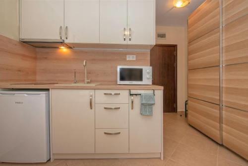 a kitchen with a white refrigerator and a microwave at Cascadas Holiday Apartments in Sunny Beach