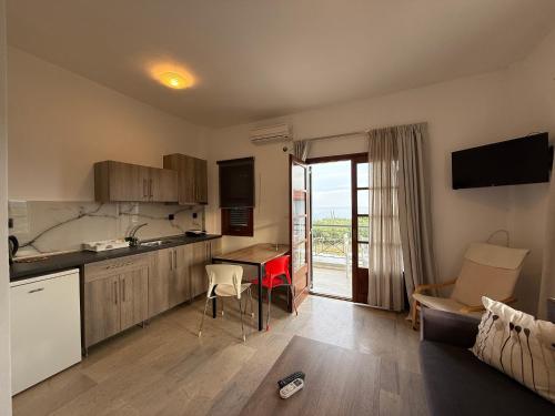 a kitchen and living room with a table and a couch at Theros Apartments in Mola Kalyva
