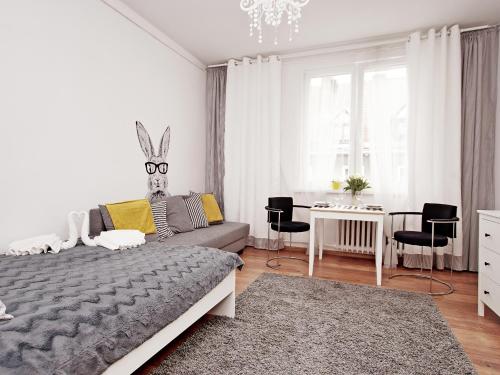 a bedroom with a bed and a table and chairs at Apartment Kameralny 2B in Gdańsk