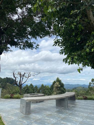 a stone bench sitting on top of a field at Benito Bungalow, Haputale by The Serendipity Collection in Haputale