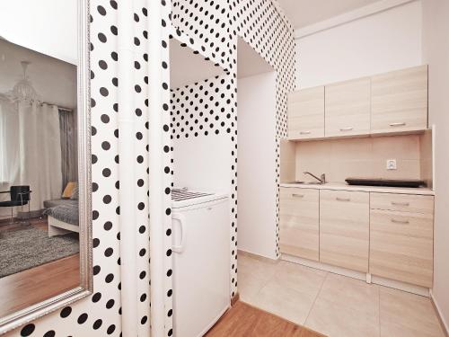 a kitchen with a mirror and a white and black wall at Apartment Kameralny 2B in Gdańsk