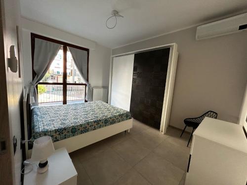 a bedroom with a bed and a large window at Casa Neghelli - Alassio in Alassio