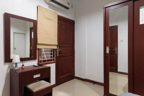 a room with a mirror and a dresser and a door at Mono Coliving Benhil, Jakarta Pusat in Jakarta