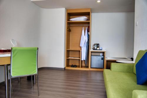 a living room with a table and a green couch at Hotel Sentral Seaview @ ​Beachfront in George Town