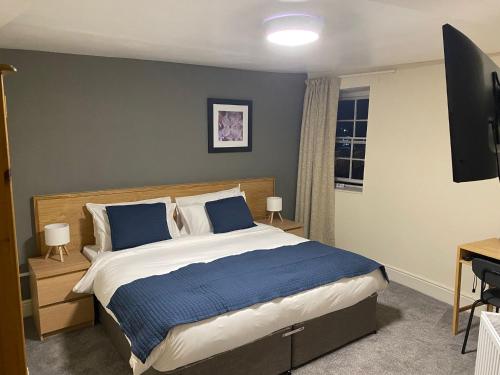 a bedroom with a bed and a flat screen tv at Blue Boar in Frome