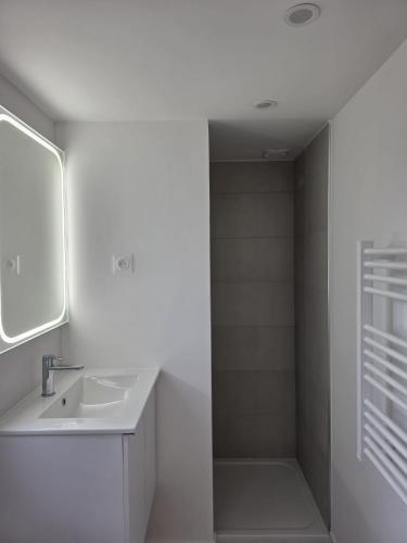 a white bathroom with a sink and a mirror at Camping du Pas Del Fang in Sainte-Marie-la-Mer