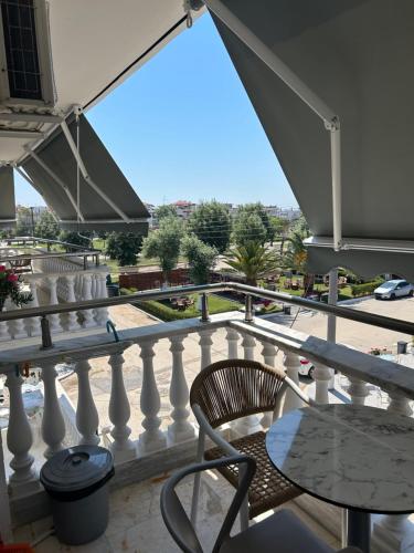 a balcony with a table and a chair at Dionisos Roses in Paralia Dionysiou