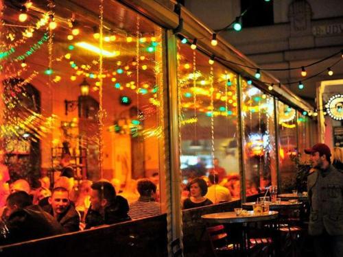 a group of people sitting in a restaurant with christmas lights at Gozsdu Court Budapest in Budapest