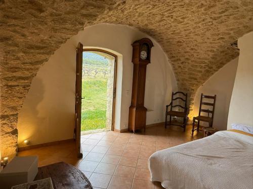 - une chambre avec un lit et une horloge dans l'établissement Bastide Neuve au Cœur du Luberon - Piscine Privée, à Lauris