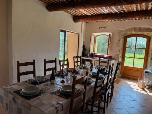 une salle à manger avec une longue table et des chaises dans l'établissement Bastide Neuve au Cœur du Luberon - Piscine Privée, à Lauris