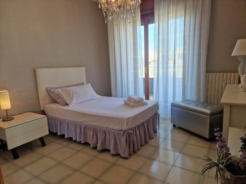 a bedroom with a bed and a chair and a chandelier at A Casa da Maria in Melissano