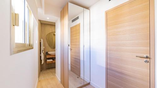 - un couloir avec une porte en bois dans la salle de bains dans l'établissement Centre Croisette - Dernier étage - 3 chambres - 3 salle de bains- Prime Location, à Cannes