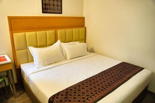 a hotel room with a bed with two pillows at Hotel Sentral Seaview @ ​Beachfront in George Town