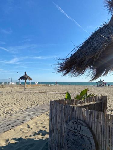 a sandy beach with an umbrella and the ocean at La casa di Barbara in Le Cerquete