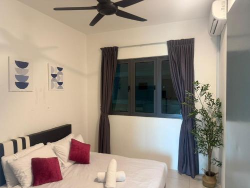 a bedroom with a bed with red pillows and a ceiling fan at Meritus Suites - 8pax in Perai
