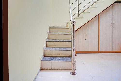 a staircase in a building with a metal hand rail at Hotel O The Buddha Residency in Dānāpur