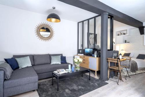un salon avec un canapé et une table dans l'établissement Keyz - Elegant Studio with Terrace near the Louvre & Le Marais, à Paris