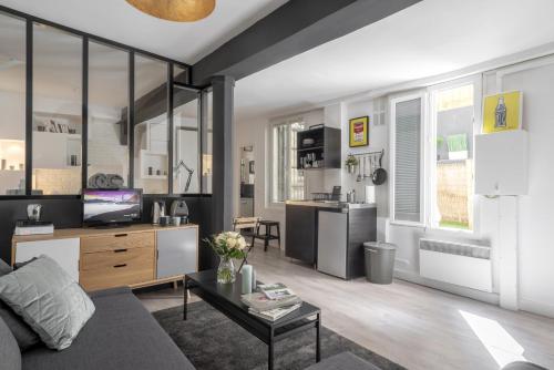 un salon avec un canapé et une table dans l'établissement Keyz - Elegant Studio with Terrace near the Louvre & Le Marais, à Paris