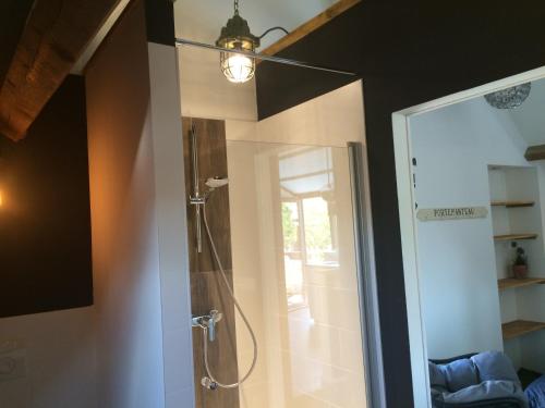 a bathroom with a shower with a light on the wall at De Weegbrug in IJzendijke