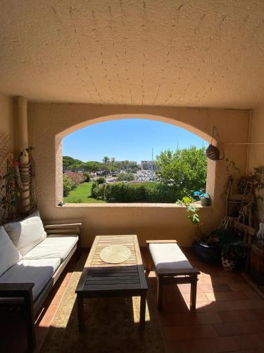 un salon avec un canapé, une table et une fenêtre dans l'établissement Studio au cœur de la marina, à Cogolin