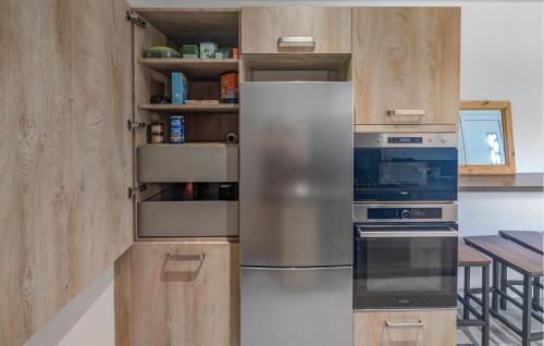 une cuisine avec un réfrigérateur en acier inoxydable et des armoires en bois dans l'établissement Stunning Apartment In Bellaffaire, à Bellaffaire