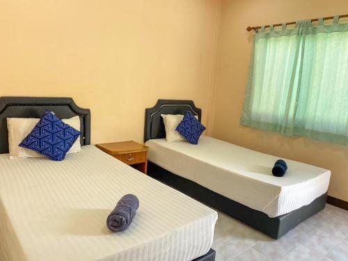 a room with two beds with blue pillows at สบายดีรีสอร์ท เมืองตาก in Ban Phae