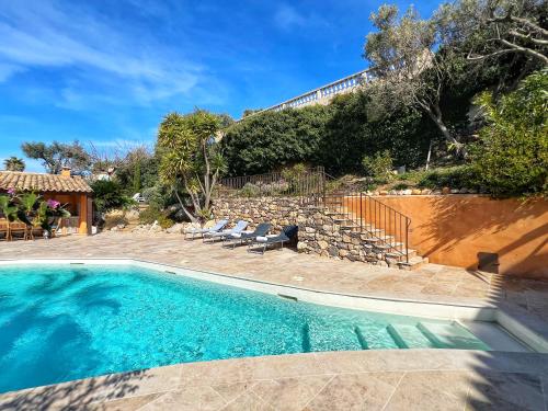 - une piscine avec des chaises à côté d'une maison dans l'établissement Magnifique villa au calme, Vue mer, piscine, à Ollioules