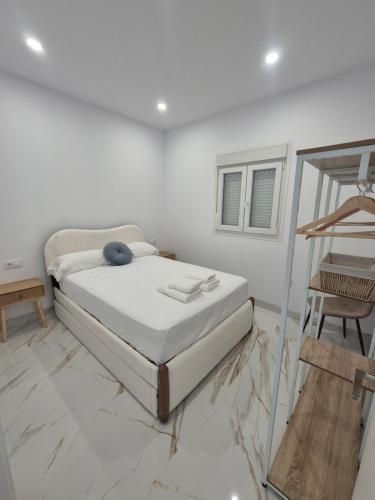 a white room with a bed and a mirror at Casitalola in Conil de la Frontera